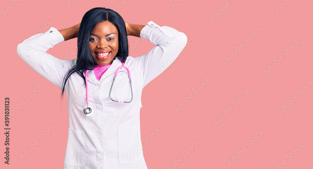 Young african american woman wearing doctor stethoscope relaxing and stretching, arms and hands behind head and neck smiling happy