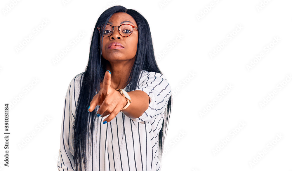 Young african american woman wearing casual clothes and glasses pointing displeased and frustrated to the camera, angry and furious with you Young african american woman wearing casual clothes and glasses pointing displeased and frustrated to the camera, angry and furious with you
