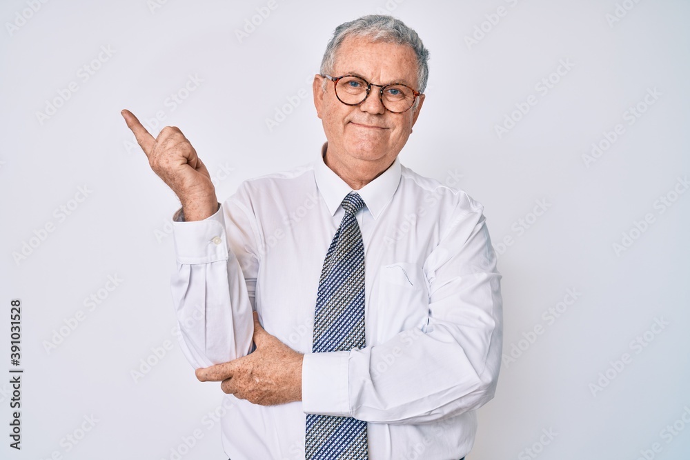 Senior grey-haired man wearing business clothes smiling happy pointing with hand and finger to the side Senior grey-haired man wearing business clothes smiling happy pointing with hand and finger to the side