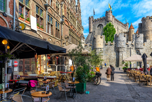 Old street with tables of cafe in Ghent (Gent), Belgium. Architecture and landmark of Ghent. Cozy cityscape of Ghent. photo