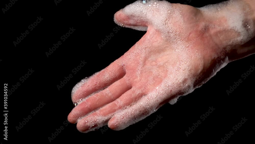 Hand palm with soapy foam with bubbles closeup on a black background. Disinfection of the body to prevent infection with coronavirus. COVID-19 global pandemic Hand palm with soapy foam with bubbles closeup on a black background. Disinfection of the body to prevent infection with coronavirus. COVID-19 global pandemic