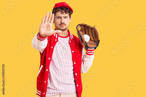 Photography Young handsome man with curly hair wearing baseball uniform holding golve and ba