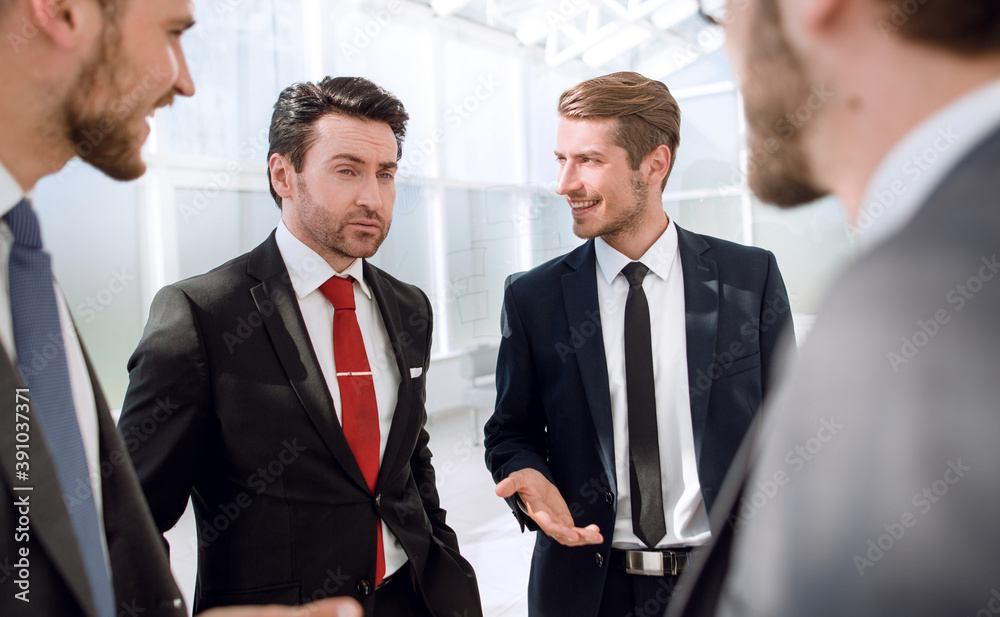 Manager and employees of the company talking standing in the office Manager and employees of the company talking standing in the office