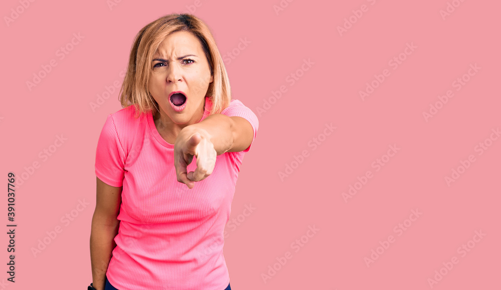 Young blonde woman wearing sportswear pointing displeased and frustrated to the camera, angry and furious with you Young blonde woman wearing sportswear pointing displeased and frustrated to the camera, angry and furious with you