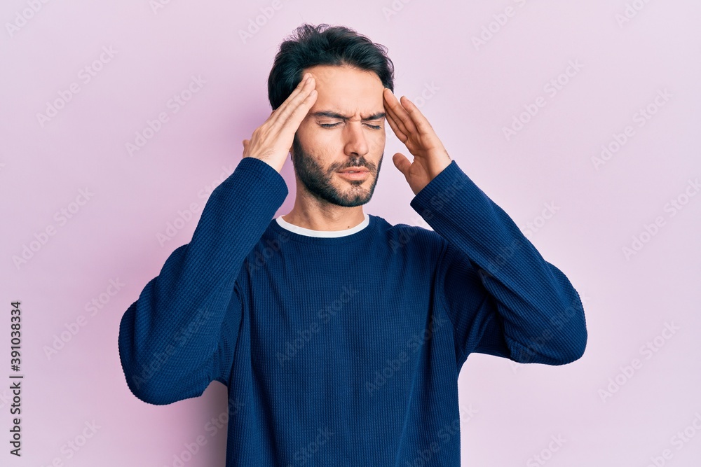 Young hispanic man wearing casual clothes with hand on head, headache because stress. suffering migraine. Young hispanic man wearing casual clothes with hand on head, headache because stress. suffering migraine.
