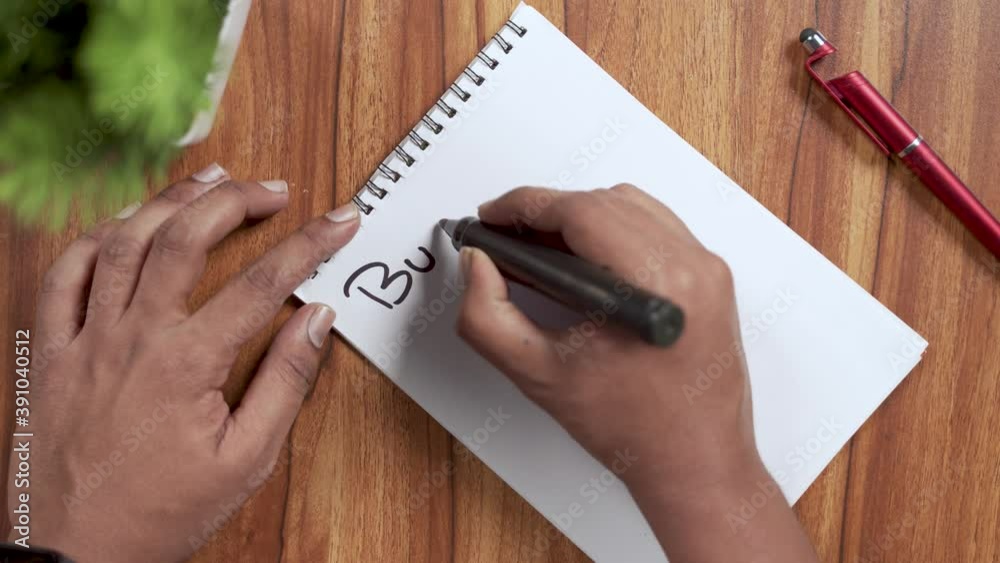POV shot of hands writing or planning down Bucket list on note book for 2021 new year.
