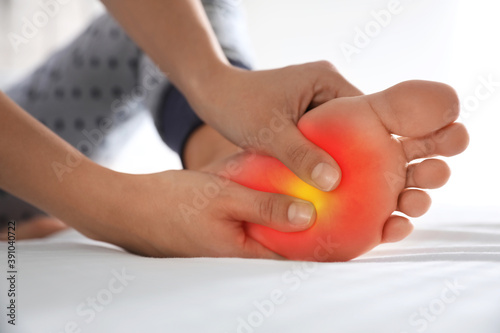 Woman suffering from foot pain at home  closeup