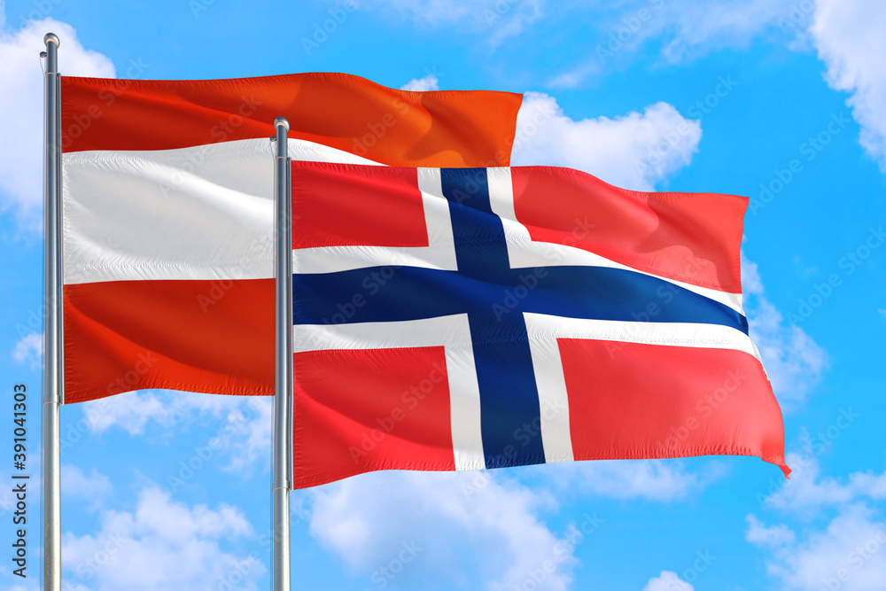 Bouvet Islands and Austria national flag waving in the windy deep blue sky. Diplomacy and international relations concept. Bouvet Islands and Austria national flag waving in the windy deep blue sky. Diplomacy and international relations concept.