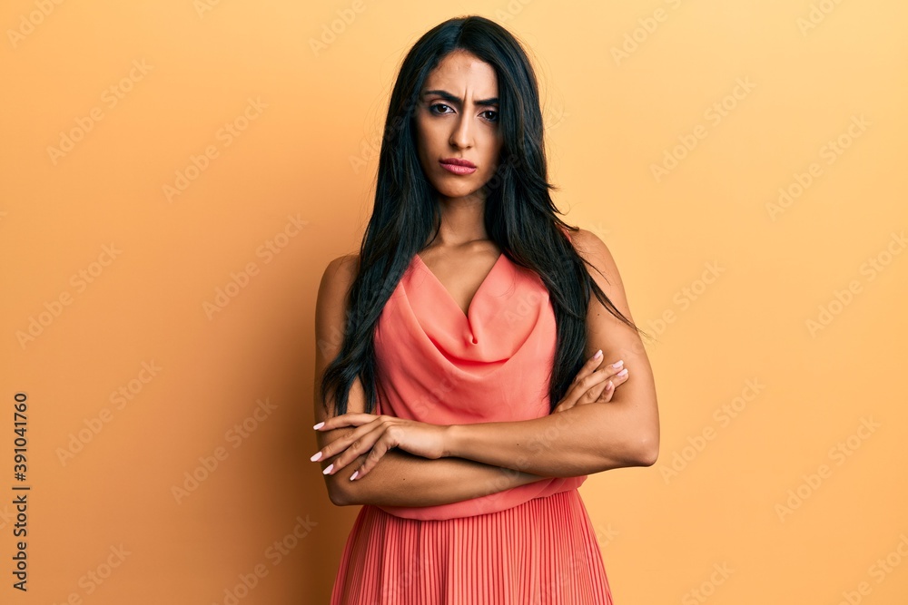 Obraz premium Beautiful hispanic woman wearing summer dress skeptic and nervous, disapproving expression on face with crossed arms. negative person.
