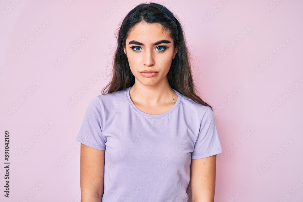 Brunette teenager girl wearing casual clothes with serious expression on face. simple and natural looking at the camera. Brunette teenager girl wearing casual clothes with serious expression on face. simple and natural looking at the camera.
