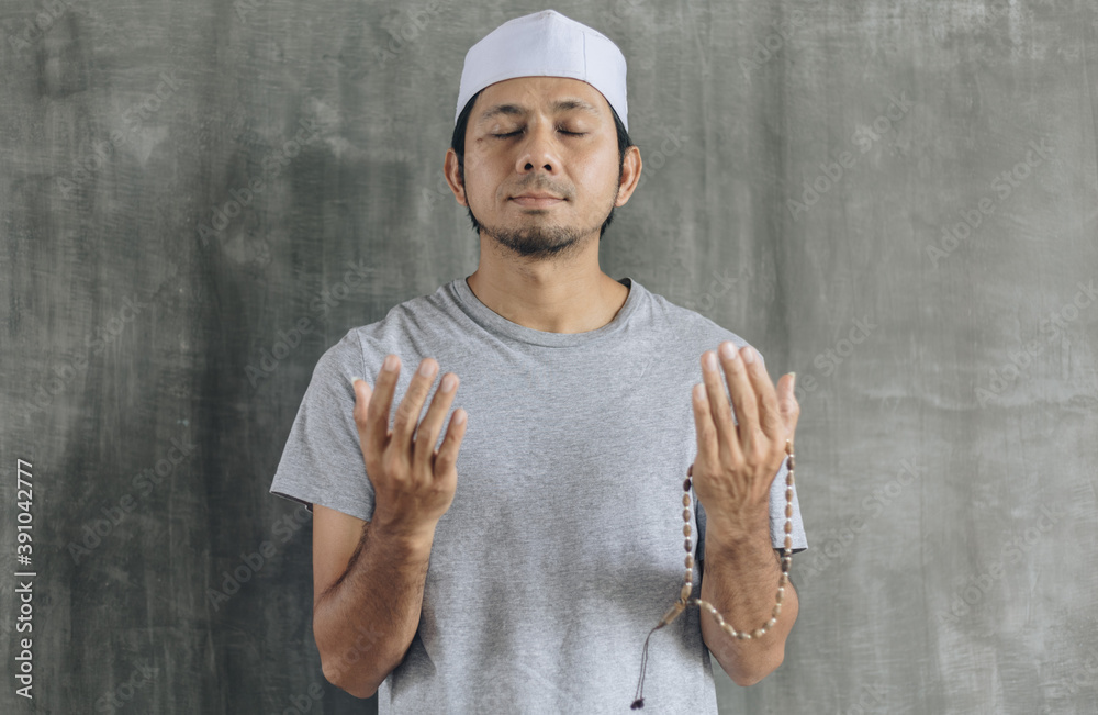 Naklejka premium Young muslim man praying with copy space 
