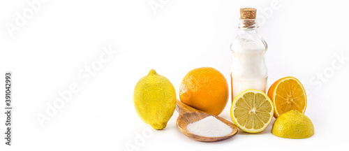 sodium bicarbonate on isolated white background, chemical compound in crystalline powders, used as antacid or yeast, with citrus fruits on the side, lemon and orange. Homemade recipes photo