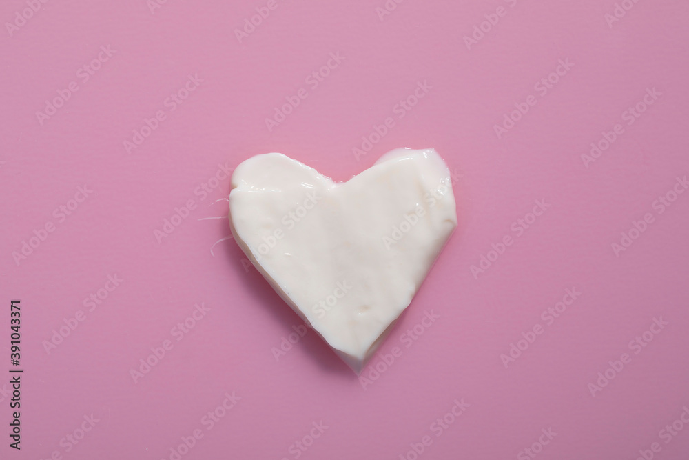 Heart shape from cream in pink background Heart shape from cream in pink background