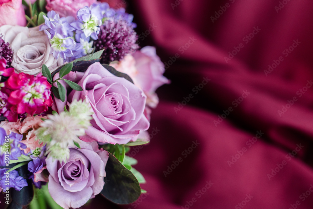 A piece of bouquet of roach roses on a purple background of fabric A piece of bouquet of roach roses on a purple background of fabric