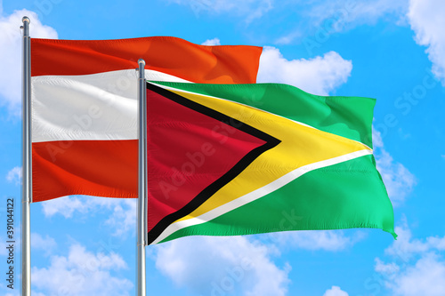 Guyana and Austria national flag waving in the windy deep blue sky. Diplomacy and international relations concept.
