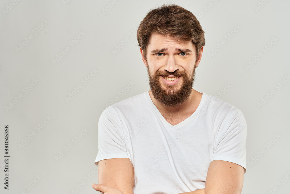man in white t-shirt gesturing with his hands studio dissatisfaction lifestyle light background man in white t-shirt gesturing with his hands studio dissatisfaction lifestyle light background