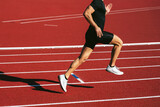 Fitness man running on the red running track. Copy space. Close Up. Lifestyle and sports