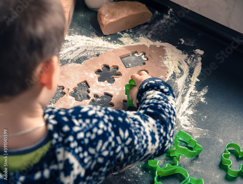 Close up of child hands making Christmas cookies with forms out of fresh ginger dough. Christmas and New Year holidays concept