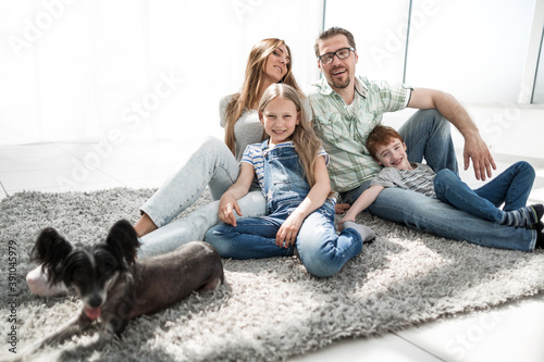 happy family with pet sitting on the carpet