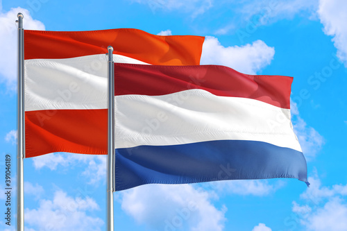 Netherlands and Austria national flag waving in the windy deep blue sky. Diplomacy and international relations concept.
