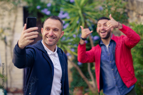 Gay couple making a funny selfie with their smartphone.