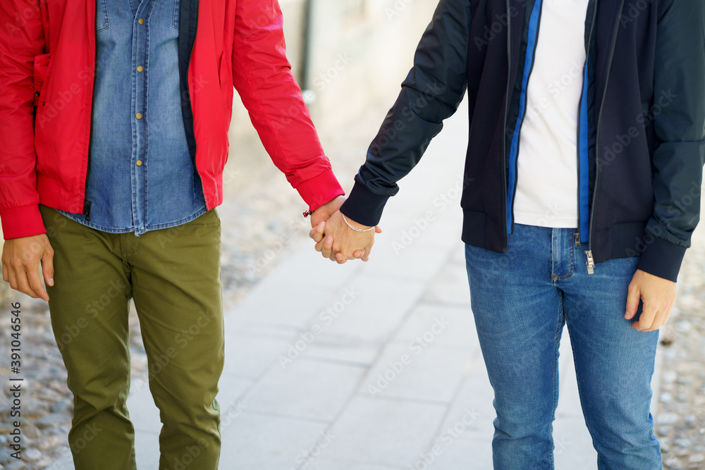 Gay couple holding hands in the street. Gay couple holding hands in the street.