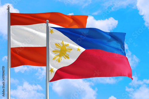 Philippines and Austria national flag waving in the windy deep blue sky. Diplomacy and international relations concept.