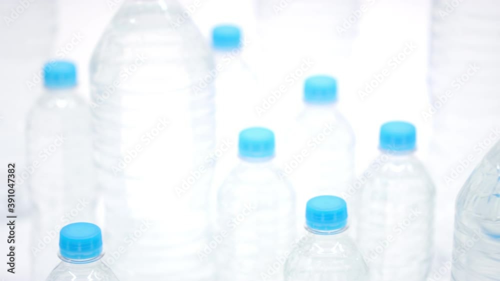 Small and big plastic bottles of mineral water with blue caps, close-up dolly shot Small and big plastic bottles of mineral water with blue caps, close-up dolly shot