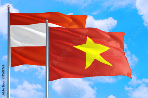 Vietnam and Austria national flag waving in the windy deep blue sky. Diplomacy and international relations concept.