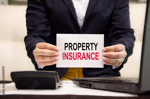  the word property insurance is written on a white piece of paper held by a girl