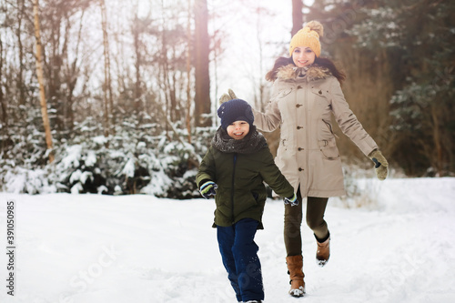 Happy family playing and laughing in winter outdoors in the snow. City park winter day.