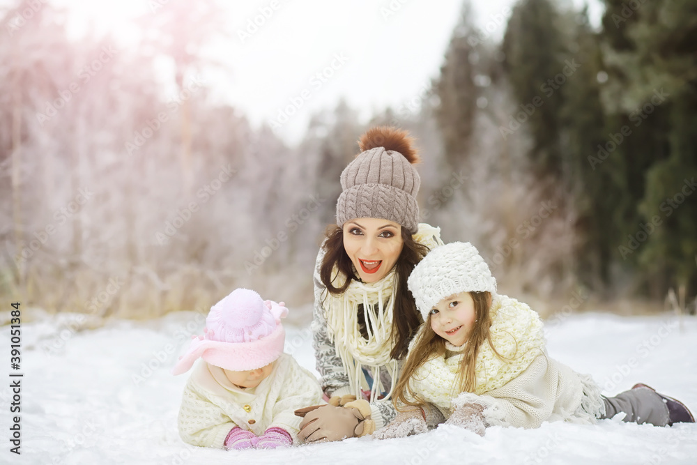 Obraz premium Happy family playing and laughing in winter outdoors in the snow. City park winter day.