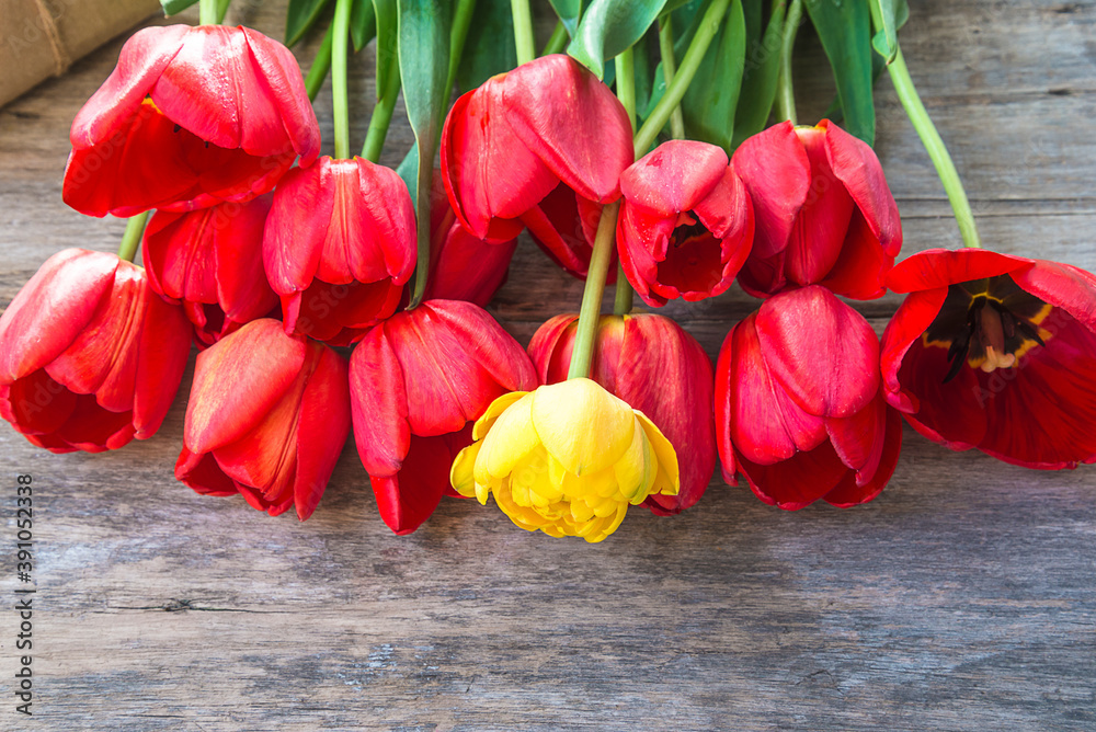 Beautiful bunch of red tulips on old wooden background. Close up, copy space, selective focus
