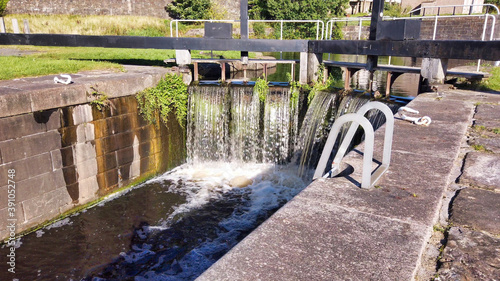 Water flowing over the wooden gates of a canal lock. photo