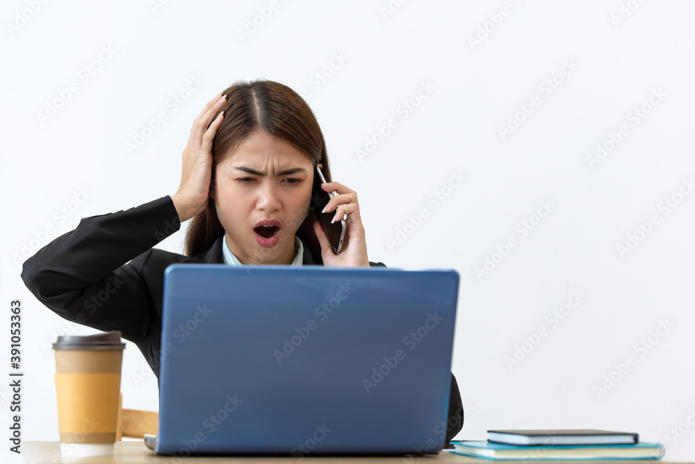 Stressed Asian businesswoman working on a laptop at her office, business concept Stressed Asian businesswoman working on a laptop at her office, business concept