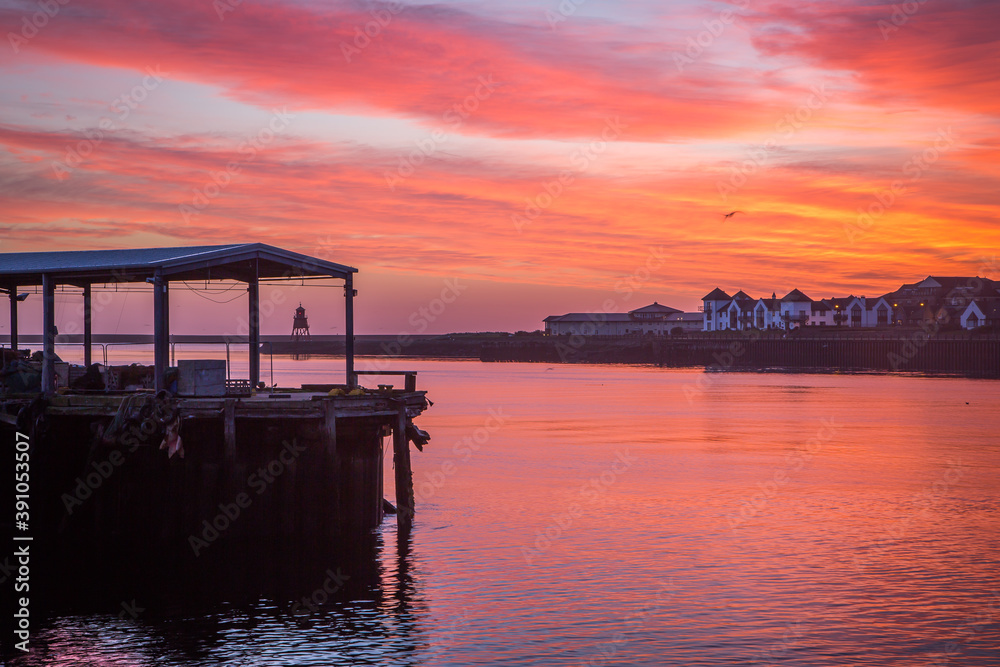 North Shields Fish Quay on a calm morning during a vivid sunrise with moored Fishing boats