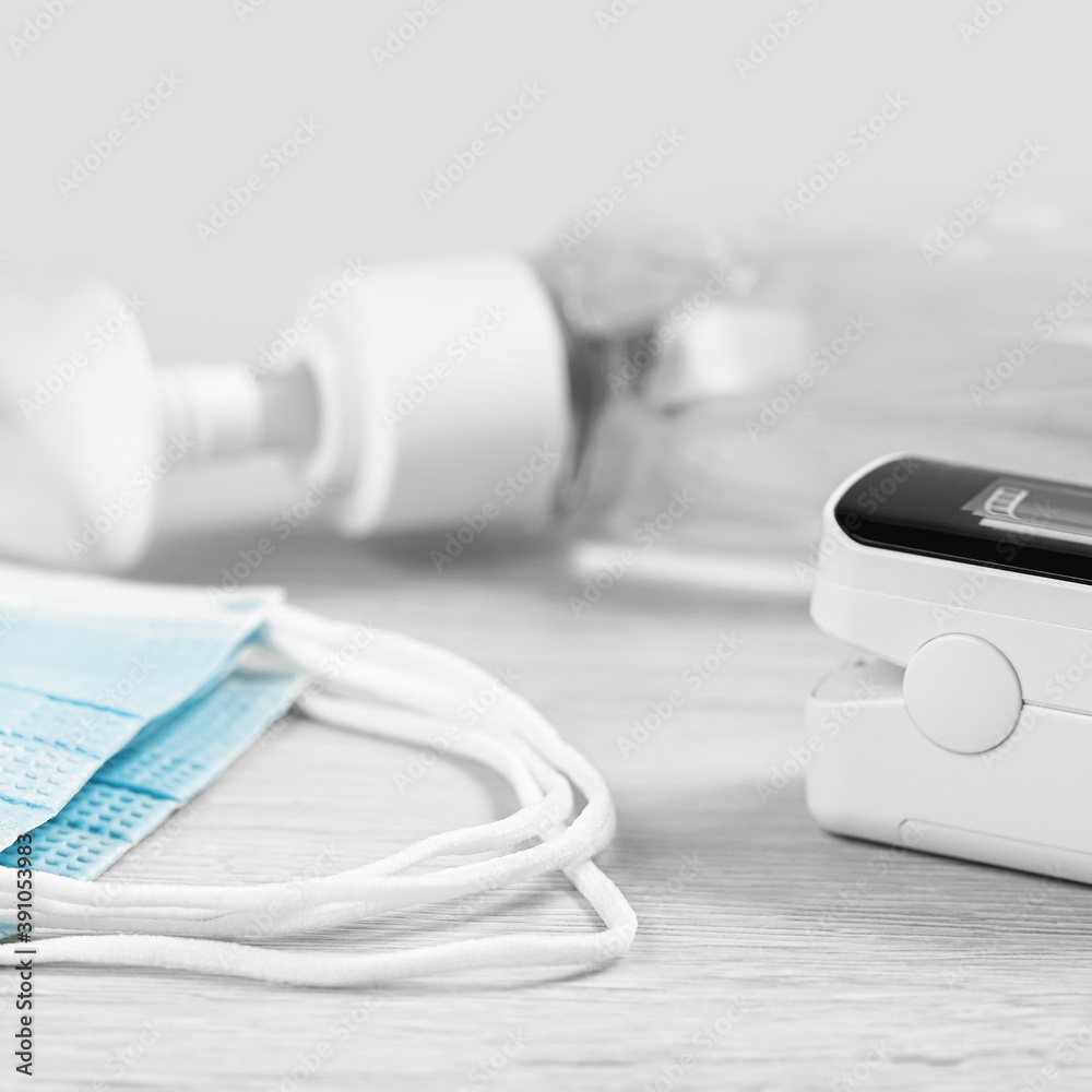 Medical concept. pulse oximeter, sanitizer and face masks. Pneumonia prevention and cure, flu sesion, lockdown. Oxygen meter for finger. Viral infection and respiratory disease protection. PPE