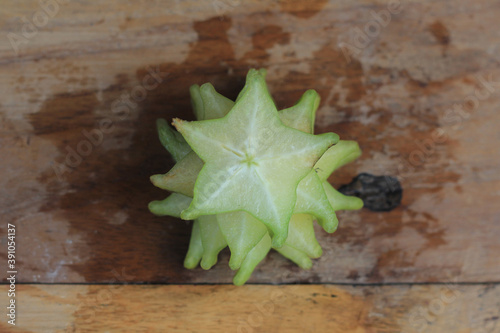Exotic sweet star fruit or star fruit averrhoa on wooden background. Perfect ingredients for a healthy, vegetarian, or vegan diet