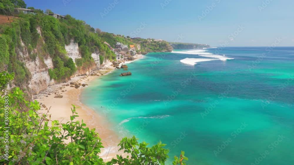 Azure beach with rocky mountains and clear water of Indian ocean at sunny day. Hidden beach in Bali, Indonesia Azure beach with rocky mountains and clear water of Indian ocean at sunny day. Hidden beach in Bali, Indonesia