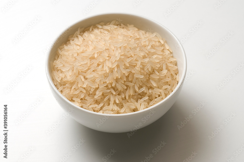 Cup filled with raw rice grains, on white background and shadow
Cup filled with raw rice grains, on white background and shadow