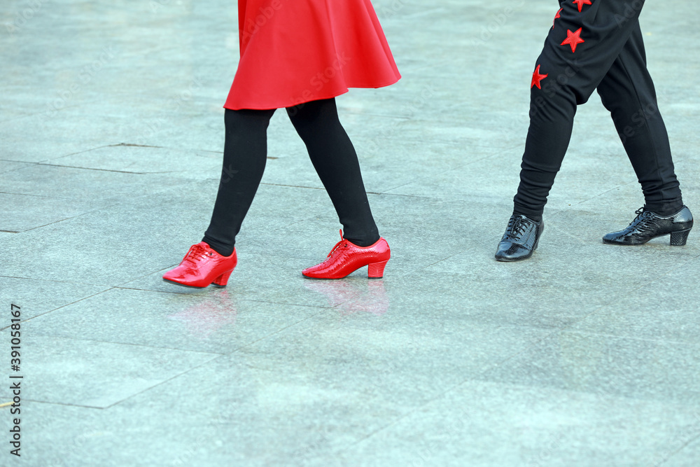 Red skirt and dance shoes, black pants, dancing in outdoor square, China Red skirt and dance shoes, black pants, dancing in outdoor square, China