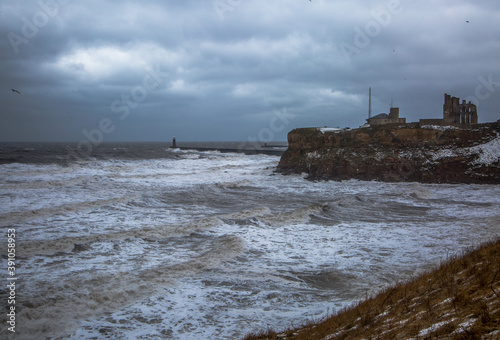 Giant waves batter King Edward's Bay during a winter storm, as the surrounding cliffs by Tynemouth Priory are covered with a sprinkling of snow