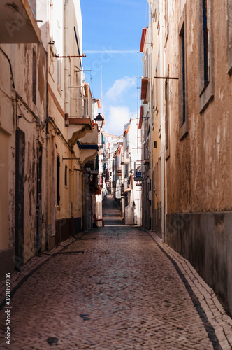 Old  narrow streets  houses of the Portuguese town. The road is lined with paving stones