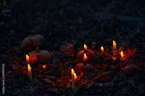 Dark autumn night background with pumpkins and burning candles. Photoshop overlay with candles and pumpkins on Samhain and Halloween