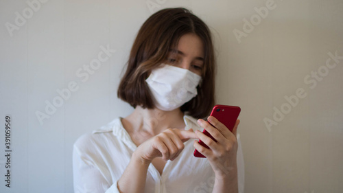 A business woman with a mask using her phone  a person using cell phone in a face mask  using smartphone in a medical mask