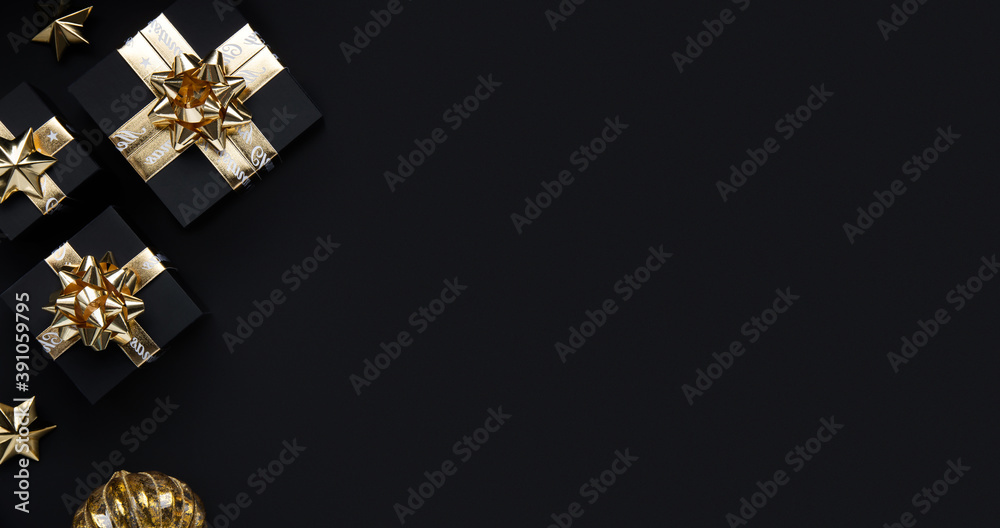 Fototapeta premium Merry Christmas and Happy Holidays greeting card, frame, banner. New Year. Noel. Christmas ornaments and gifts on black background top view. Winter xmas holiday theme. Flat lay 