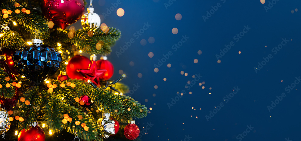 Decorated with ornaments and lights Christmas tree on blue background.  Merry Christmas and Happy Holidays greeting card, frame, banner. New Year.  Noel Stock Photo | Adobe Stock