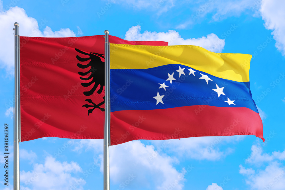 Venezuela and Albania national flag waving in the windy deep blue sky. Diplomacy and international relations concept. Venezuela and Albania national flag waving in the windy deep blue sky. Diplomacy and international relations concept.