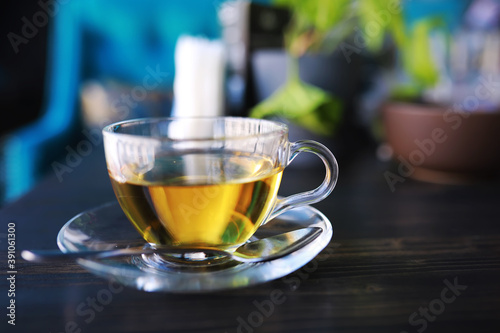 Hot steaming green tea in a cup on a rustic background