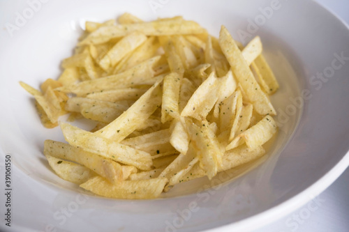 white plate with potato chips, close up